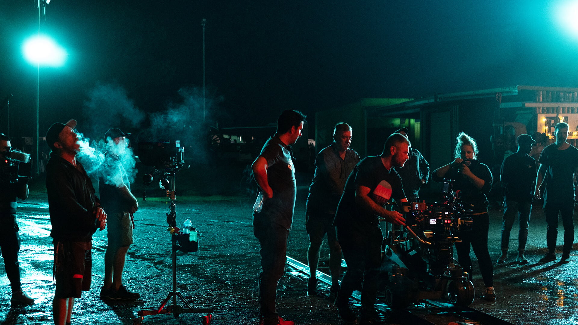 Plateau de tournage éclairé par deux grands projecteurs au loin
